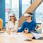 Pracownicy w okularach VR uczestniczący w szkoleniu w nowoczesnym biurze.